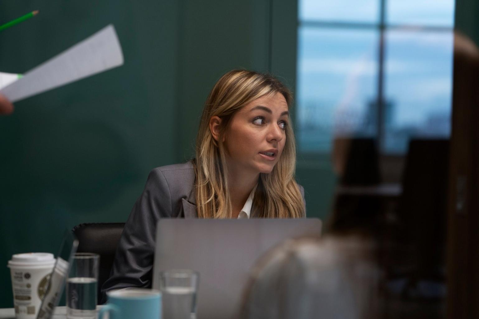 Groupe de participants travaillant en collaboration sur des analyses financières avec graphiques au tableau